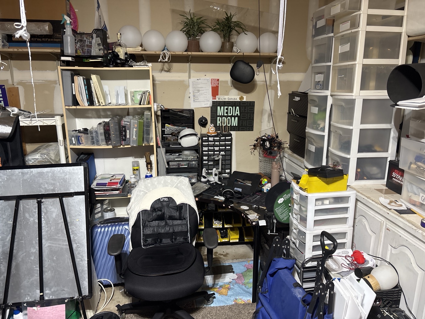 The garage media-room corner before the rebuild — cluttered shelves and gear